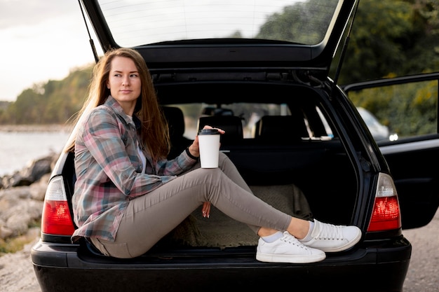 Mujer joven disfrutando de viaje por carretera