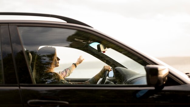 Mujer joven disfrutando de viaje por carretera