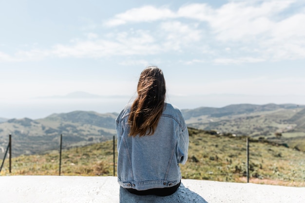 Mujer joven disfrutando de la vista de las montañas