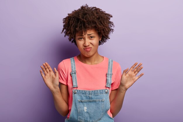 Mujer joven disgustada con un afro posando con un mono