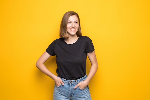 Mujer joven divertida en suéter amarillo, sonriendo ampliamente,