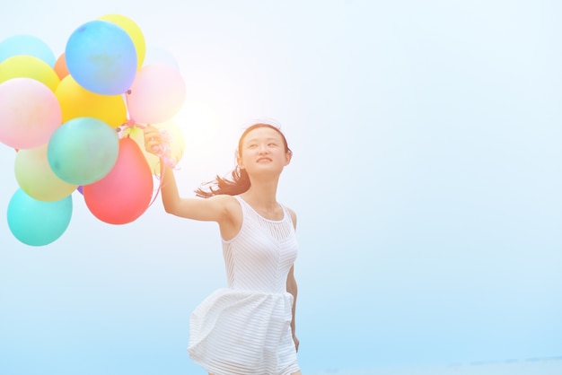 Mujer joven divirtiéndose con globos coloridos