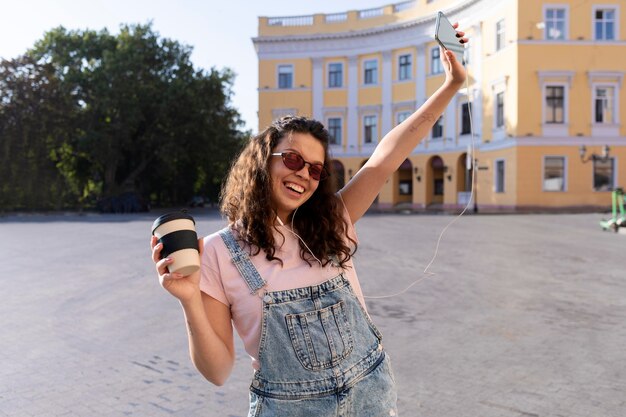 Mujer joven divirtiéndose mientras sostiene una taza de café