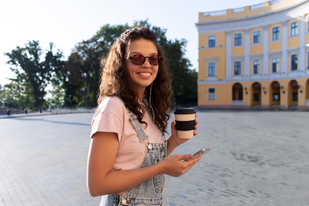 Foto gratuita mujer joven divirtiéndose mientras sostiene una taza de café