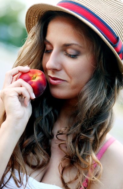 Foto gratuita mujer joven con durazno fresco en la mano