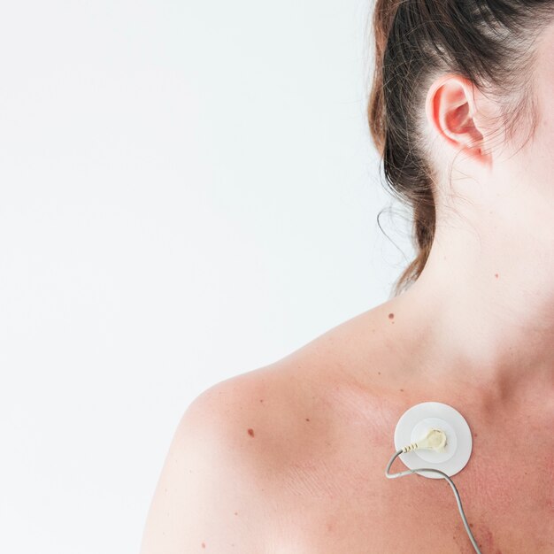 Mujer joven con electrodo en el cuerpo