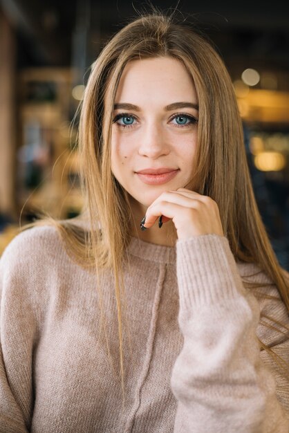 Mujer joven elegante positiva atractiva en café