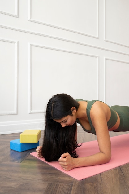 Foto gratuita mujer joven con elementos esenciales de yoga