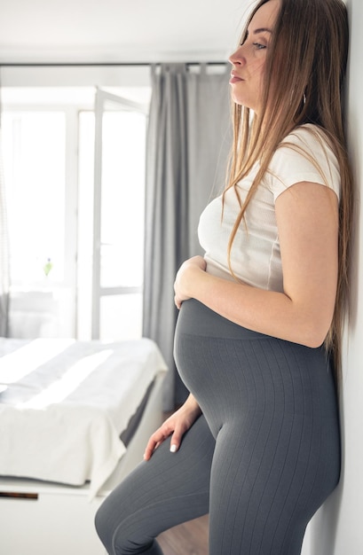 Foto gratuita mujer joven embarazada con una gran barriga en el interior de la habitación.