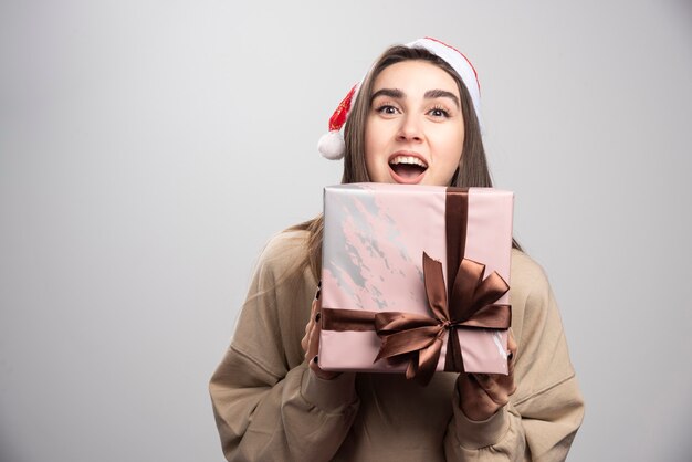 Mujer joven emocionada por una caja de regalo de Navidad.