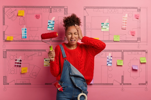 Foto gratuita mujer joven se encuentra junto al boceto de diseño de la casa listo para la renovación