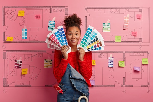 Foto gratuita mujer joven se encuentra junto al boceto de diseño de la casa listo para la renovación