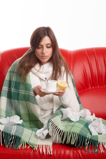 Foto gratuita mujer joven enferma mirando su taza de té