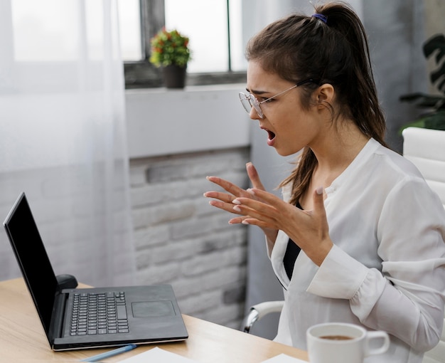 Foto gratuita mujer joven enojada trabajando desde casa