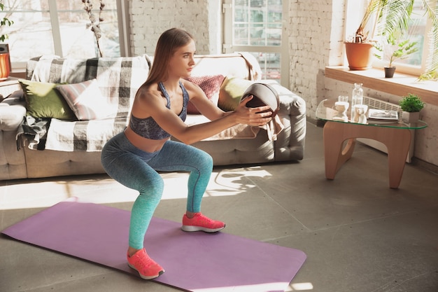 Mujer joven enseñando en casa cursos online de fitness