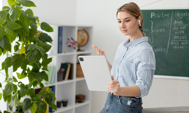 Mujer joven enseñando a los estudiantes en la clase de inglés en línea