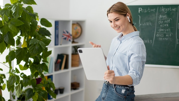 Mujer joven enseñando a los estudiantes en la clase de inglés en línea