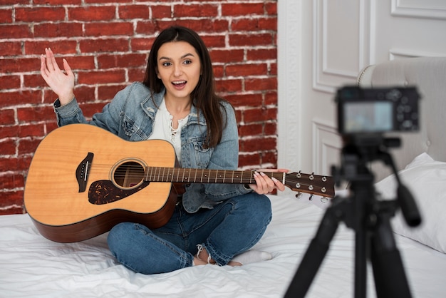 Mujer joven enseñando a tocar la guitarra