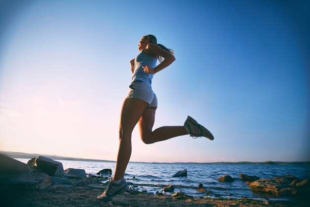 Mujer joven entrenando en la playa