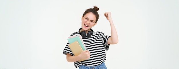 Foto gratuita mujer joven entusiasta con gafas maestra celebrando levantando la mano y animando tirumphing con