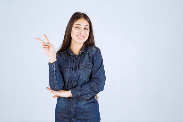 Mujer joven enviando paz y amistad al mundo.