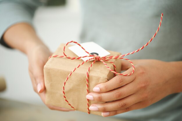 Mujer joven envolviendo regalo de Navidad