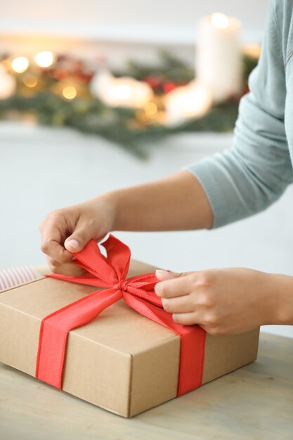 Mujer joven envolviendo regalos de Navidad