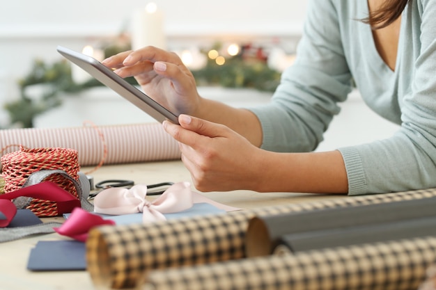 Mujer joven envolviendo regalos de Navidad