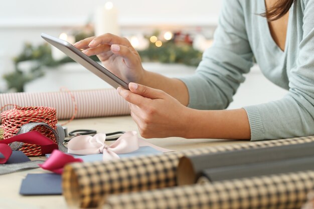 Mujer joven envolviendo regalos de Navidad