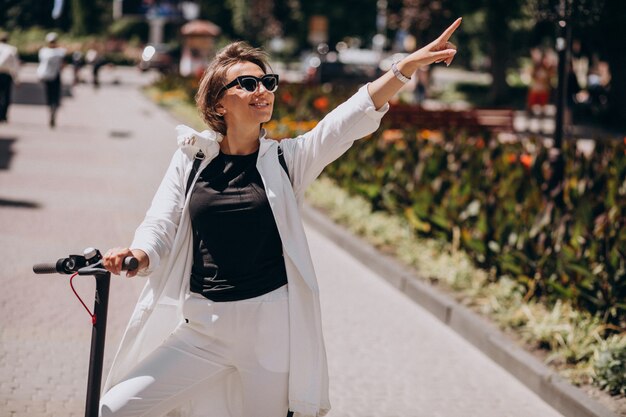 Mujer joven, equitación, patineta, en la calle