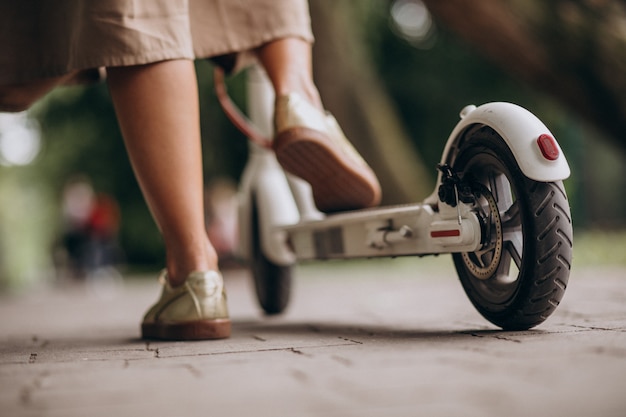 Foto gratuita mujer joven, equitación, patineta, en el estacionamiento, pies, cicatrizarse