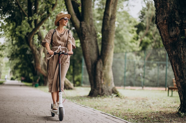 Mujer joven, equitación, patineta, en el estacionamiento