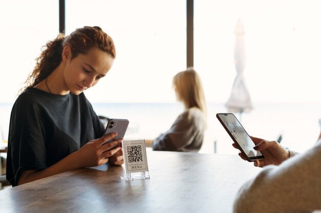 Mujer joven escaneando código qr