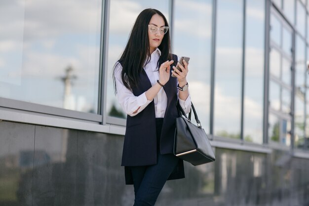 Mujer jóven escribiendo un móvil