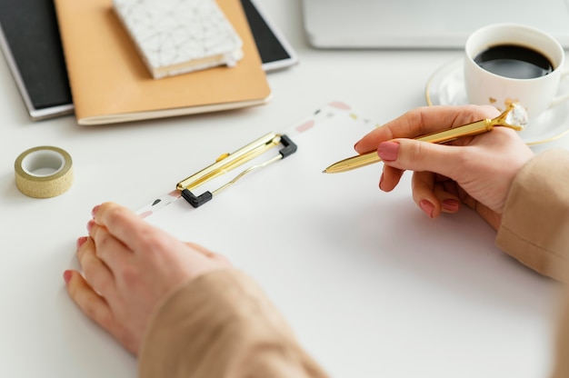 Mujer joven escribiendo notas en un portapapeles