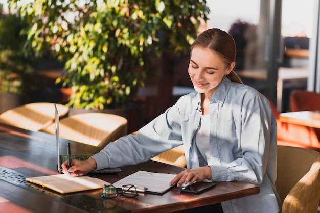 Mujer joven escribiendo en un portapapeles