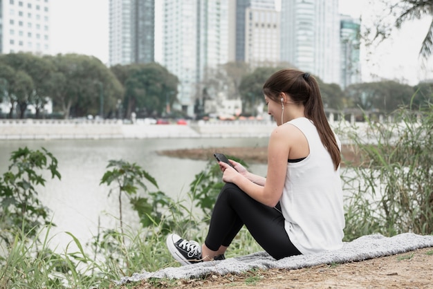 Mujer joven escuchando música al aire libre