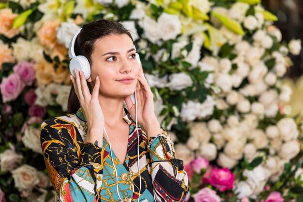 Mujer joven escuchando música en casa verde