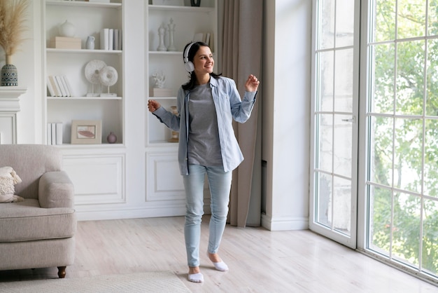 Mujer joven escuchando música en casa