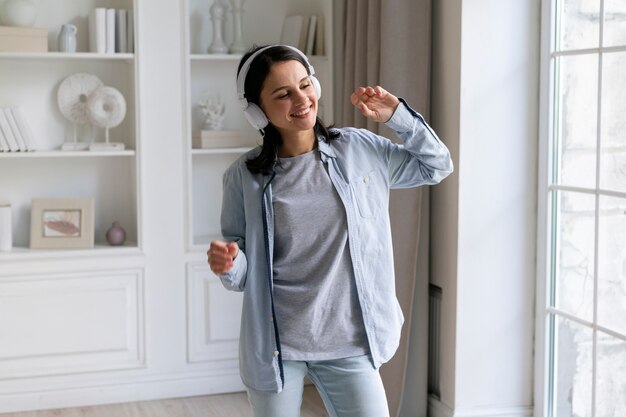 Mujer joven escuchando música en casa