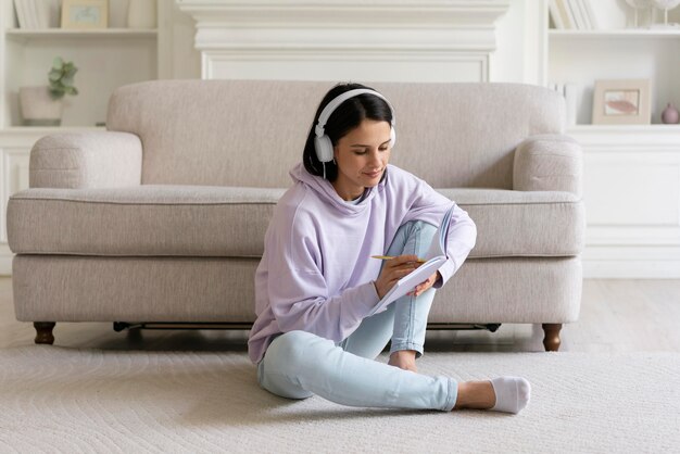 Mujer joven escuchando música en casa