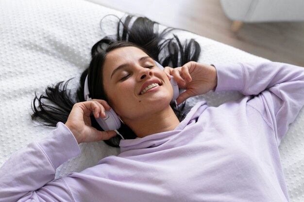 Mujer joven escuchando música en casa