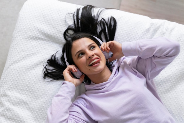 Mujer joven escuchando música en casa