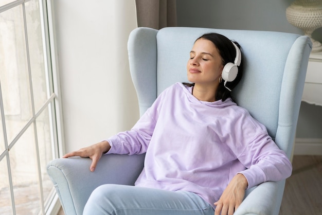 Mujer joven escuchando música en casa