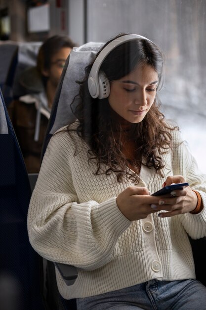 Mujer joven escuchando música mientras viaja en tren