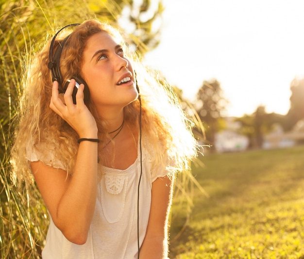 Foto gratuita mujer joven escuchando música y mirando hacia arriba