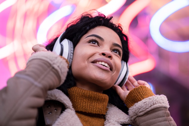 Mujer joven escuchando música a través de auriculares