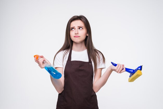 Mujer joven con esponja y spray. Concepto de servicio de limpieza de la casa.