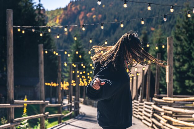 Una mujer joven está bailando contra el telón de fondo de las montañas.