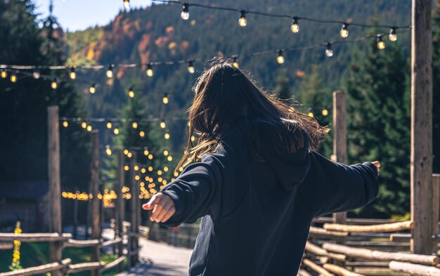 Una mujer joven está bailando contra el telón de fondo de las montañas.